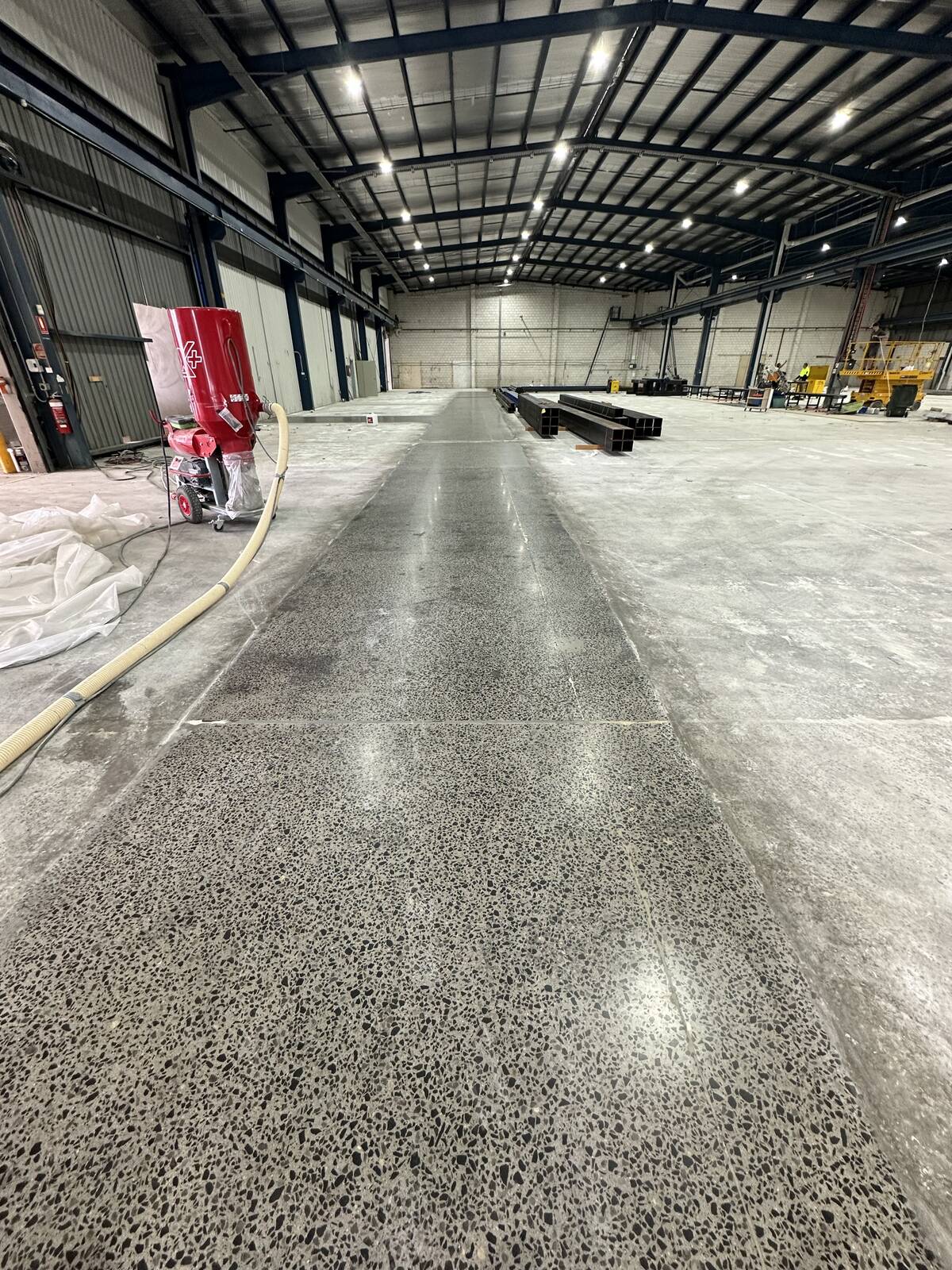 Warehouse concrete slab part-way through grinding and polishing on the Paragon Care project, by JA Floors
